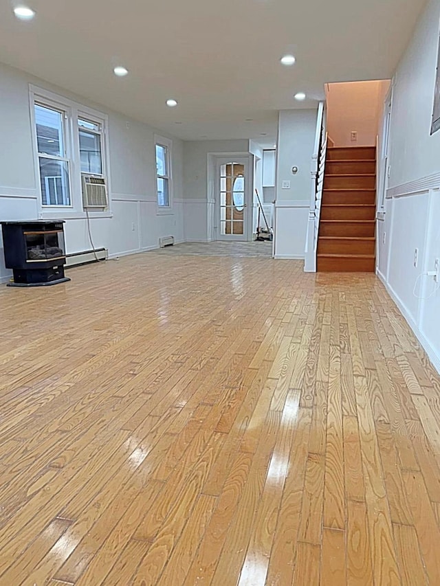 unfurnished living room featuring light hardwood / wood-style floors and baseboard heating