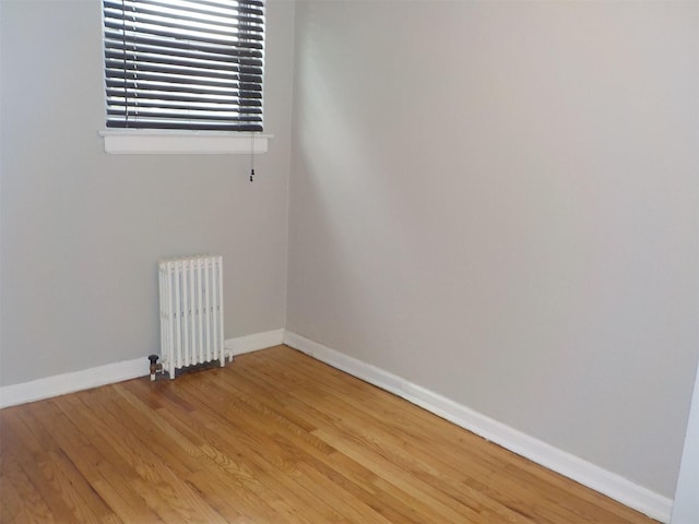 unfurnished room with wood-type flooring and radiator