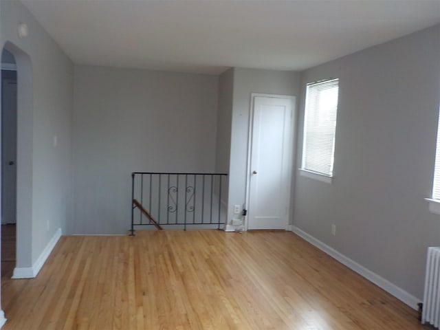 empty room with radiator and light hardwood / wood-style floors