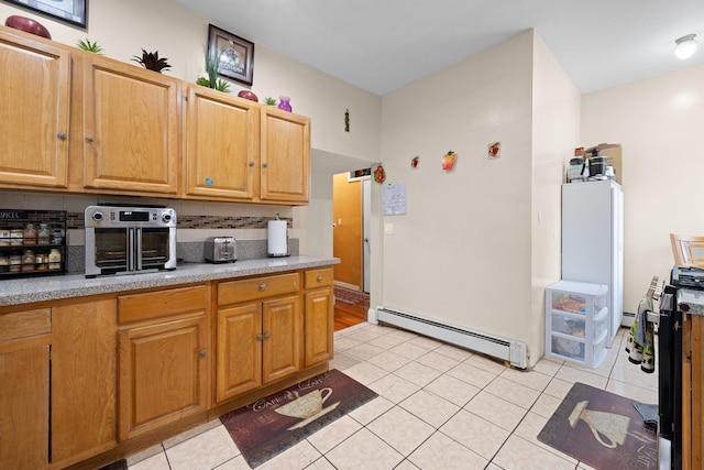 kitchen featuring a baseboard heating unit, light tile patterned floors, and decorative backsplash