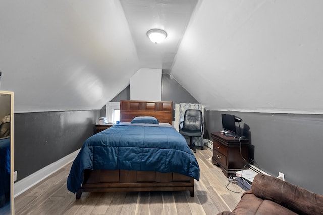 bedroom featuring vaulted ceiling and light hardwood / wood-style flooring