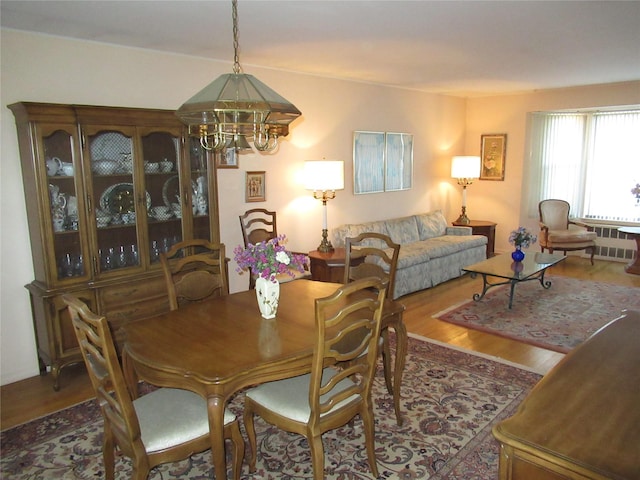 dining space featuring wood-type flooring and a chandelier