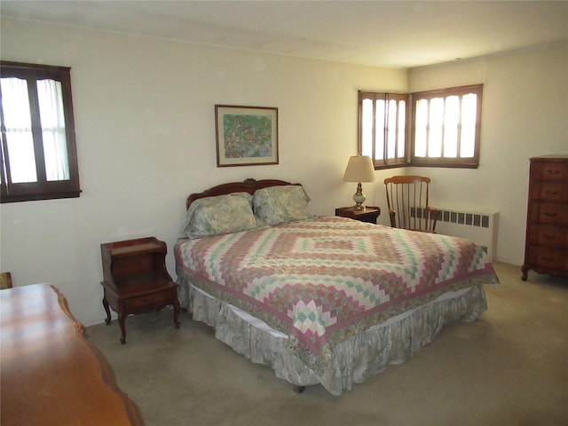 carpeted bedroom featuring radiator and multiple windows