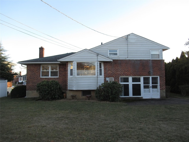 back of property featuring a lawn