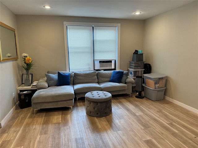 living room with cooling unit and light hardwood / wood-style flooring