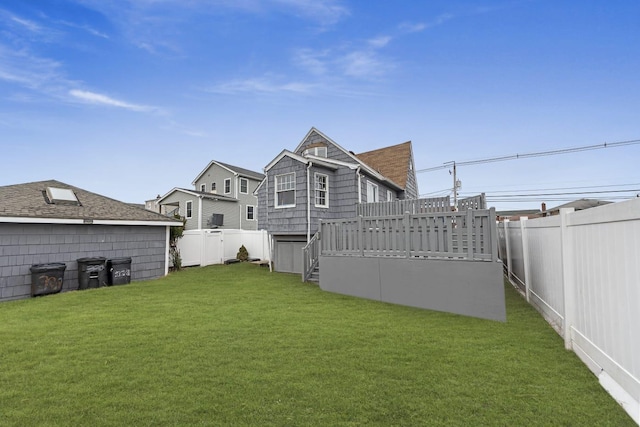 rear view of house featuring a deck and a yard