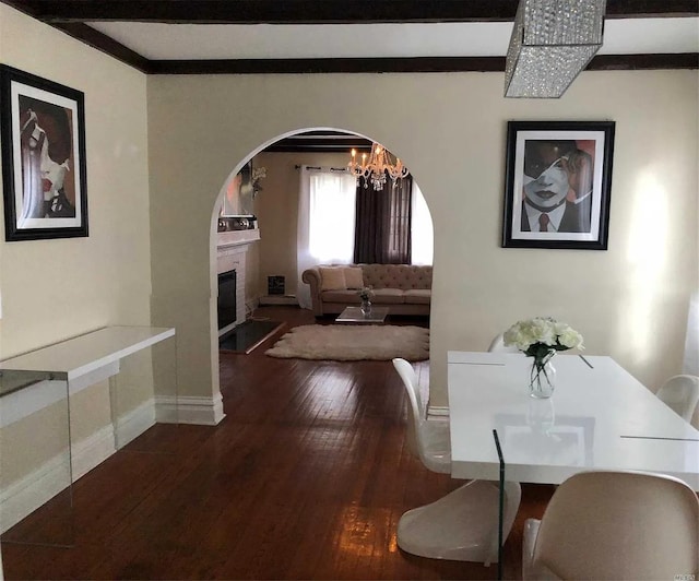 dining space featuring beam ceiling and dark hardwood / wood-style flooring