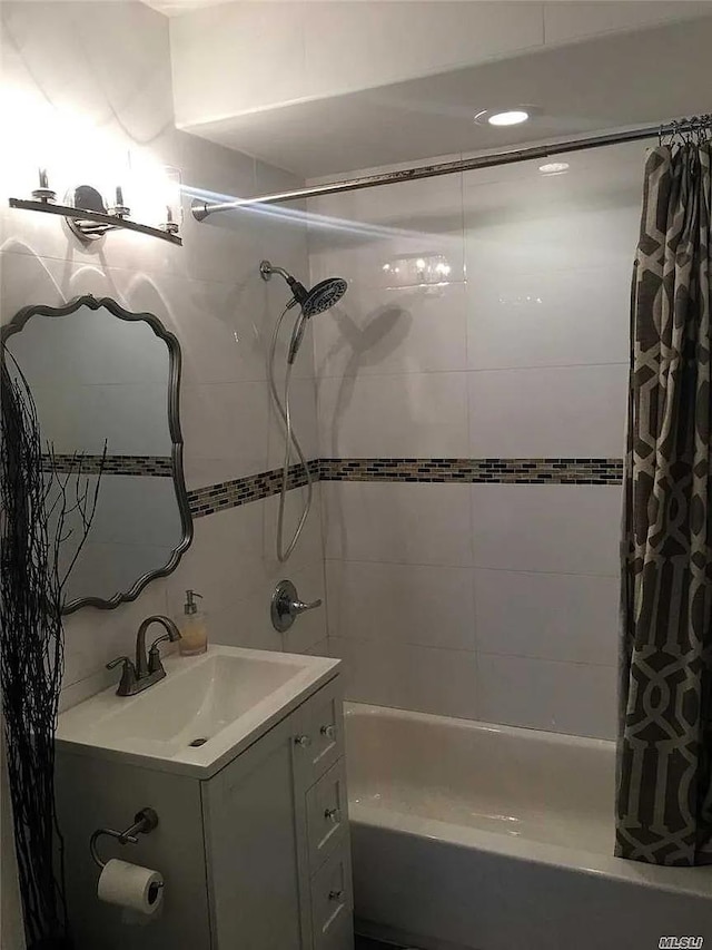 bathroom featuring shower / tub combo and vanity