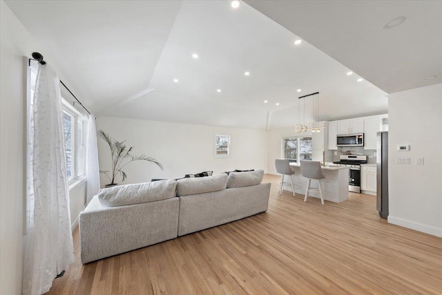 living room featuring vaulted ceiling and light wood-type flooring