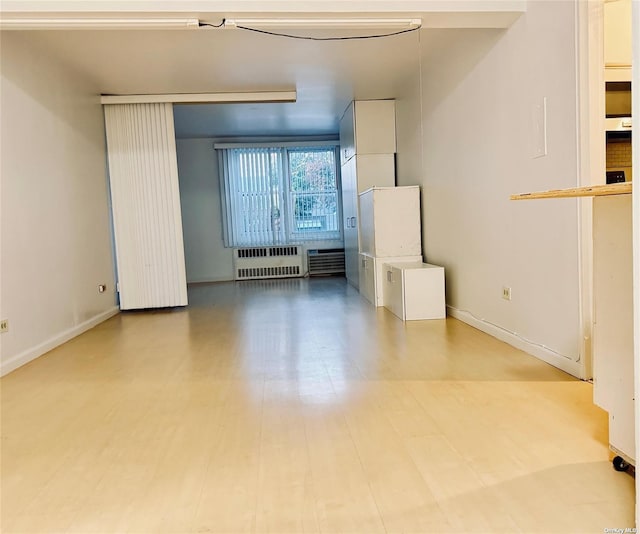 unfurnished room with radiator heating unit