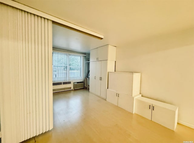 interior space with beamed ceiling and radiator heating unit