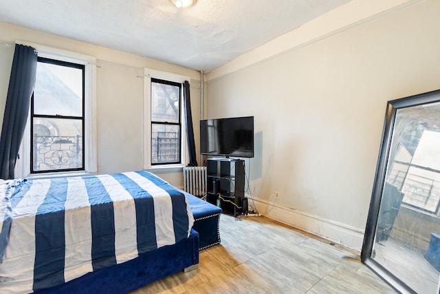 bedroom featuring radiator and a textured ceiling