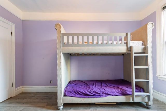 bedroom with hardwood / wood-style flooring and multiple windows