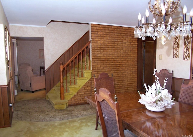 tiled dining room featuring a notable chandelier, wood walls, and ornamental molding