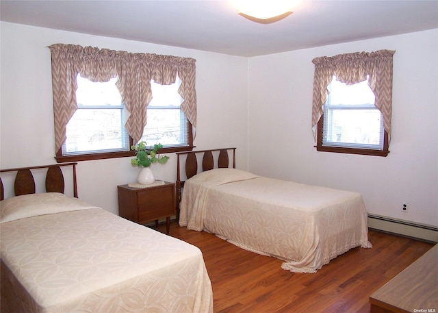 bedroom with baseboard heating and dark hardwood / wood-style floors