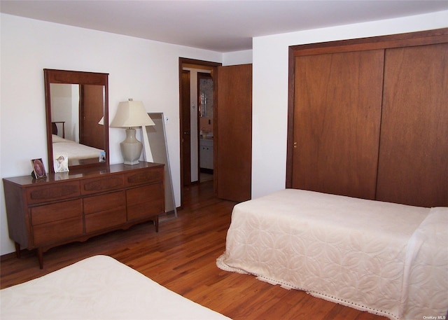 bedroom with a closet and dark hardwood / wood-style flooring