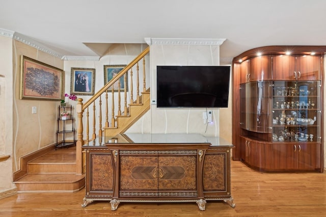 living room with crown molding and light wood-type flooring