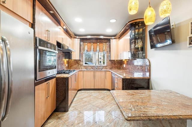 kitchen with stainless steel appliances, pendant lighting, backsplash, and light stone counters