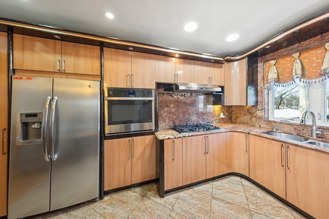 kitchen with stone countertops, appliances with stainless steel finishes, sink, and backsplash