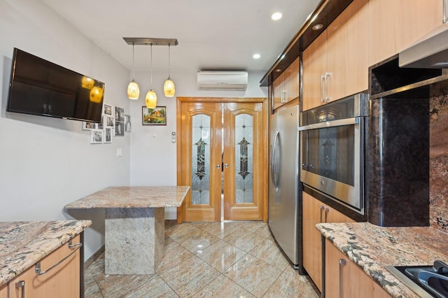 kitchen featuring rail lighting, light stone counters, an AC wall unit, pendant lighting, and stainless steel appliances