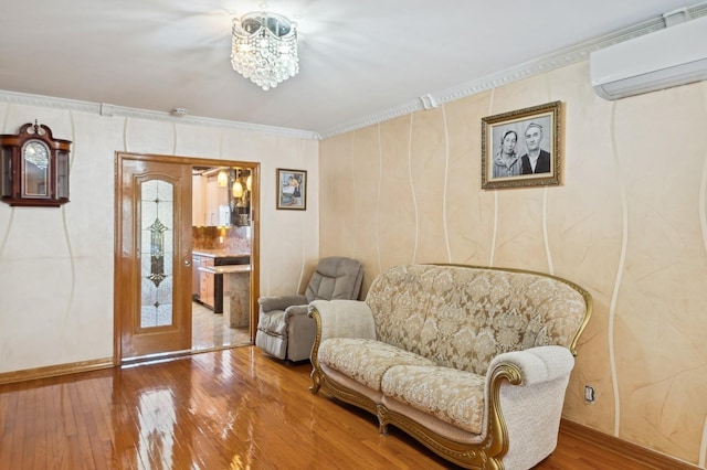 sitting room featuring ornamental molding, a wall mounted AC, and hardwood / wood-style floors