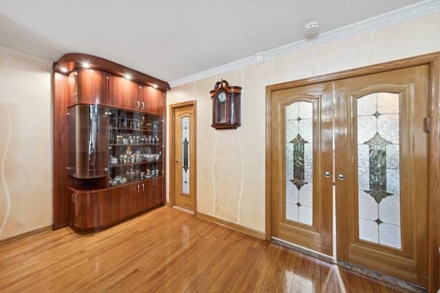 entryway featuring crown molding and light hardwood / wood-style floors