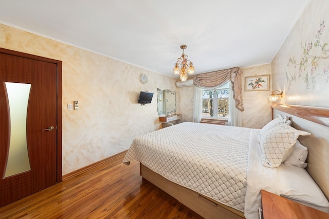 bedroom with an AC wall unit, dark hardwood / wood-style floors, and an inviting chandelier