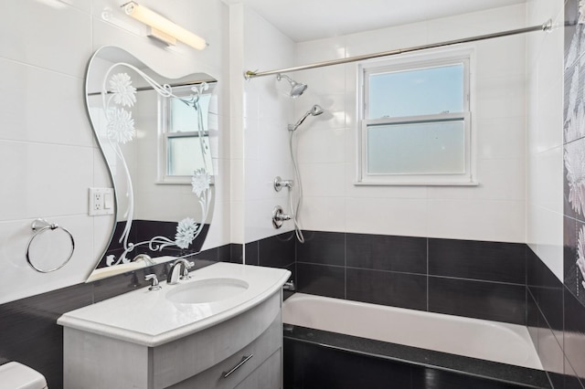 full bathroom featuring vanity, tiled shower / bath combo, and toilet