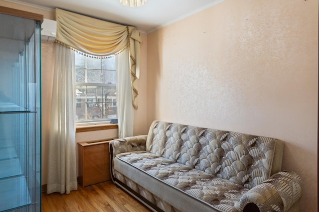 living area with crown molding and light wood-type flooring