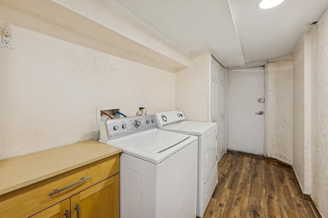 clothes washing area with cabinets, dark hardwood / wood-style floors, and washer and dryer