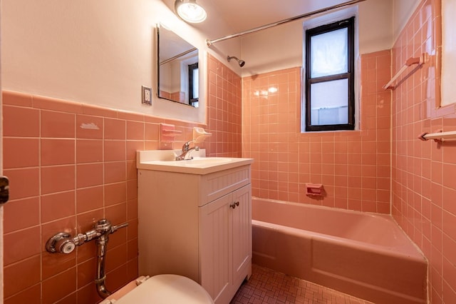 full bathroom with tile patterned flooring, tile walls, tiled shower / bath combo, toilet, and vanity