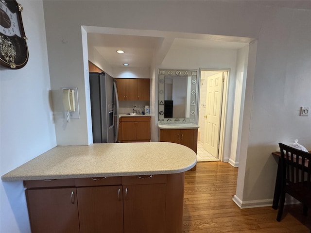 kitchen with sink, hardwood / wood-style floors, and stainless steel fridge