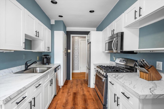 kitchen featuring stainless steel appliances, dark hardwood / wood-style floors, sink, and white cabinets