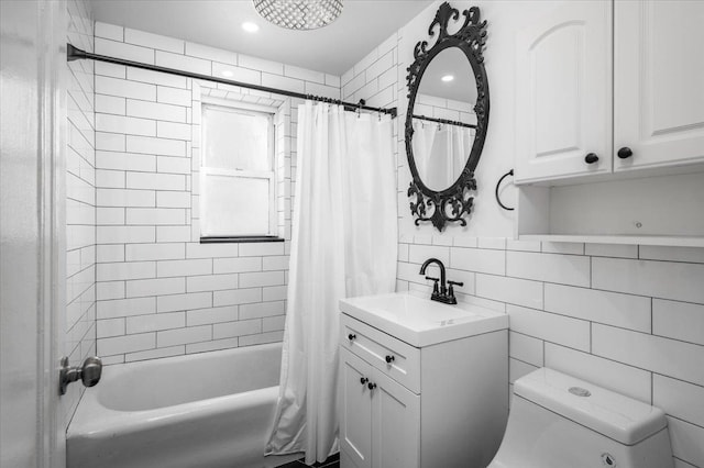 full bathroom with tile walls, decorative backsplash, vanity, toilet, and shower / bath combo