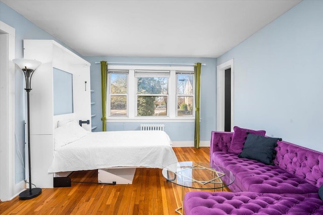 bedroom featuring radiator and hardwood / wood-style floors