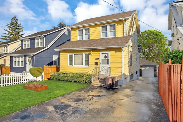 view of front facade featuring a garage, a front lawn, and an outdoor structure