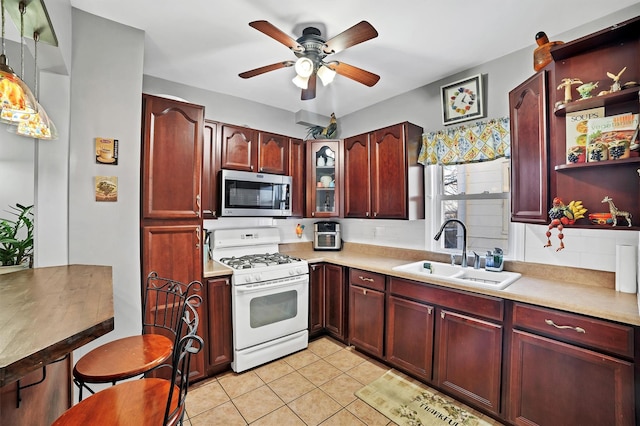 kitchen featuring sink, pendant lighting, white gas range, and tasteful backsplash