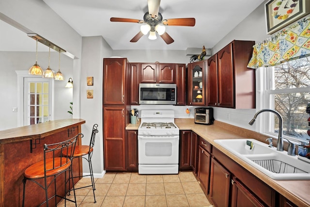 kitchen featuring light tile patterned floors, sink, decorative light fixtures, white range with gas stovetop, and ceiling fan