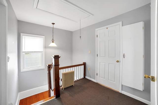 corridor with radiator heating unit and dark colored carpet