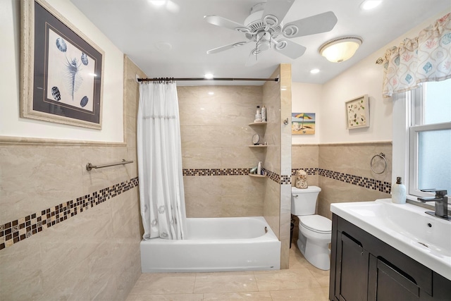 full bathroom with toilet, tile walls, vanity, ceiling fan, and shower / bathtub combination with curtain