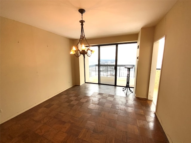 empty room featuring dark parquet floors and a chandelier