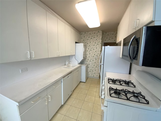 kitchen featuring light tile patterned floors, sink, white cabinets, and dishwasher