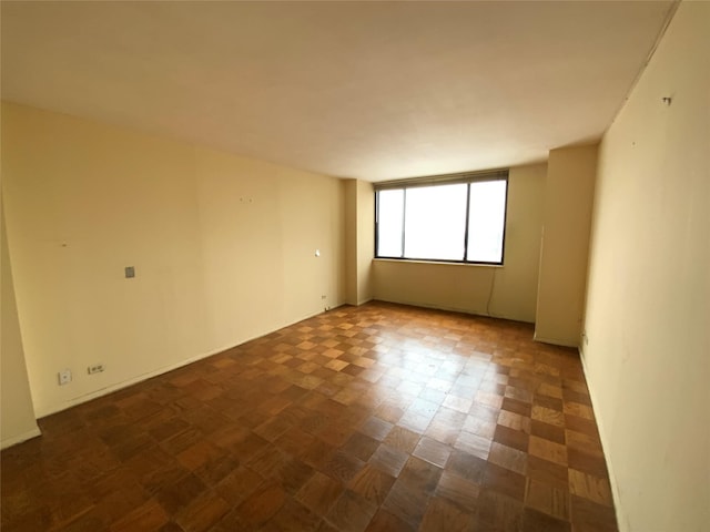 spare room with dark parquet floors