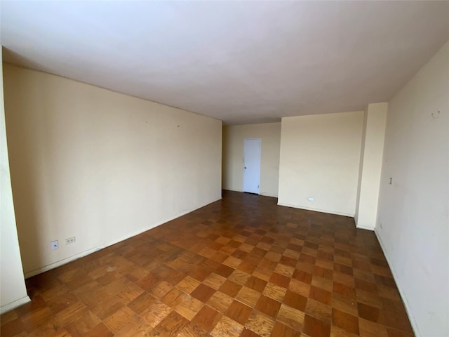 spare room featuring dark parquet floors