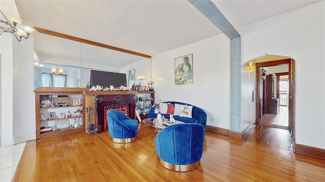 living area with a fireplace, wood-type flooring, and a notable chandelier