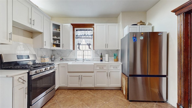 kitchen featuring sink, white cabinets, stainless steel appliances, and tasteful backsplash