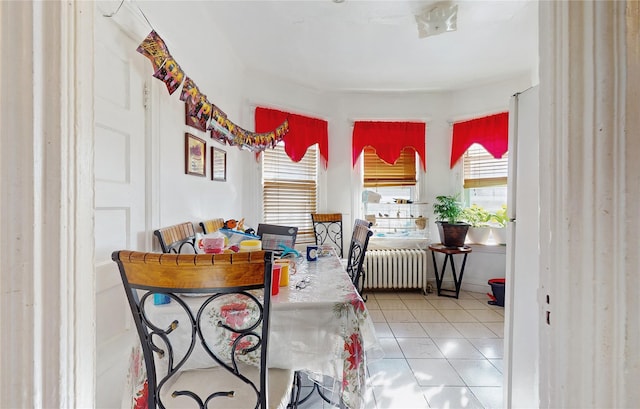 dining space featuring radiator and tile patterned flooring