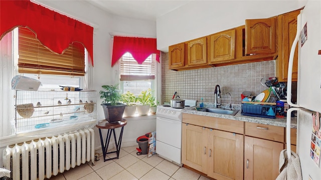 kitchen with white appliances, radiator heating unit, tasteful backsplash, sink, and light tile patterned flooring