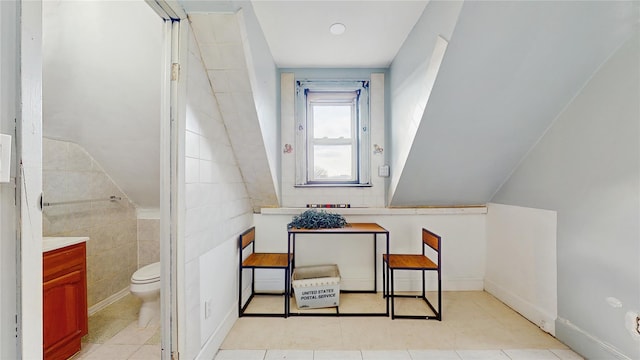 bathroom with toilet, tile walls, and tile patterned floors