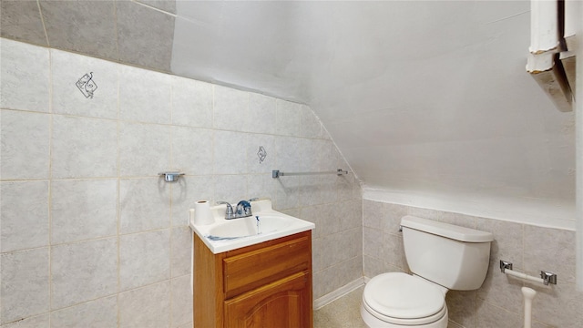 bathroom featuring toilet, vanity, and vaulted ceiling